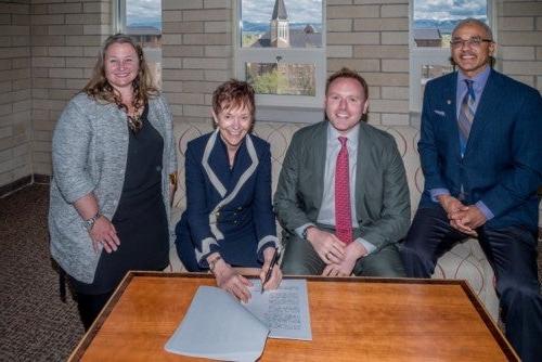 University of Denver Chancellor Rebecca Chopp signs a partnership with Andrew Hermalyn, 2U公司战略合作执行副总裁. 院长Brent Chrite和院长Am和a Moore McBride也加入了他们的行列.